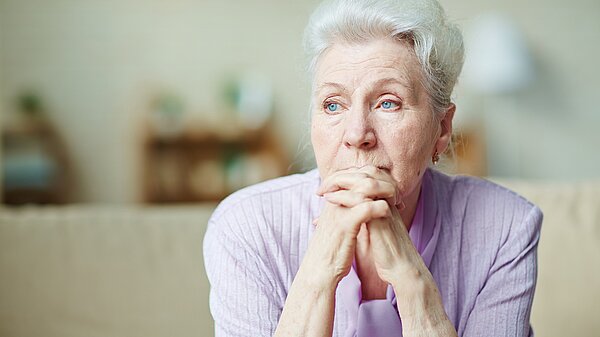 An elderly woman looking worried.