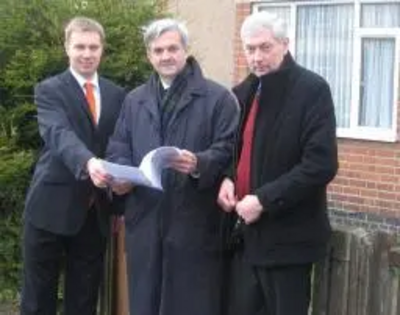 Michael Mullaney, Chris Huhne MP and Michael Gould outside the site of the planned Barwell Community House