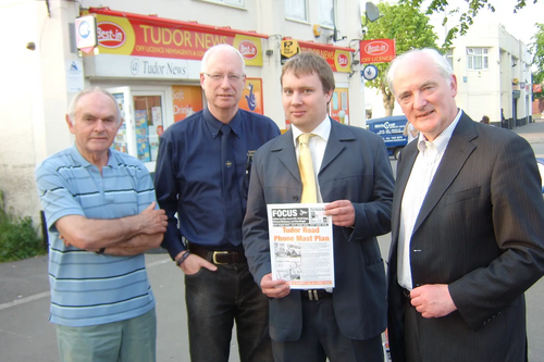 Lib Dem Councillors, David Bill, Dave Cope, Michael Mullaney and Don Wright at the site of the proposed mast on Tudor Road, Hinckley, with a copy of the petition and showing the markings where the planned mast is to go.